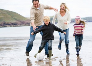 Family playing football on beach